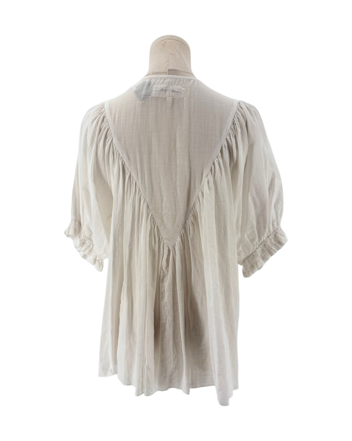 White ruffle triangle top, v-shaped ruffle down the body, voluminous short sleeves, round neckline on a mannequin on a white background