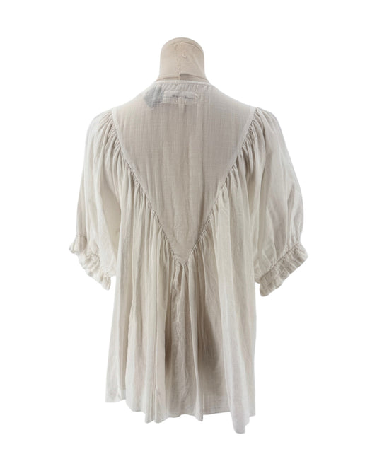 White ruffle triangle top, v-shaped ruffle down the body, voluminous short sleeves, round neckline on a mannequin on a white background