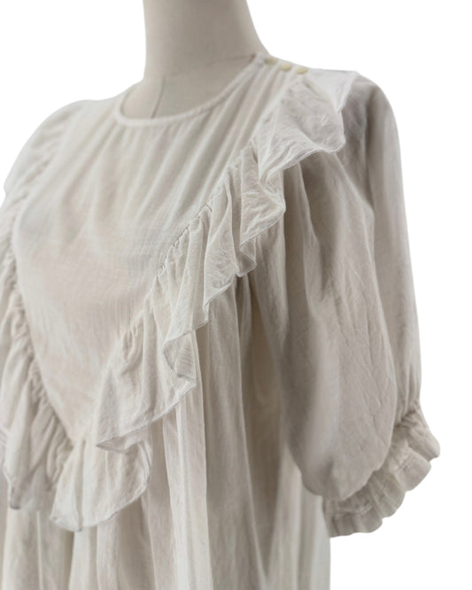 White ruffle triangle top, v-shaped ruffle down the body, voluminous short sleeves, round neckline on a mannequin on a white background