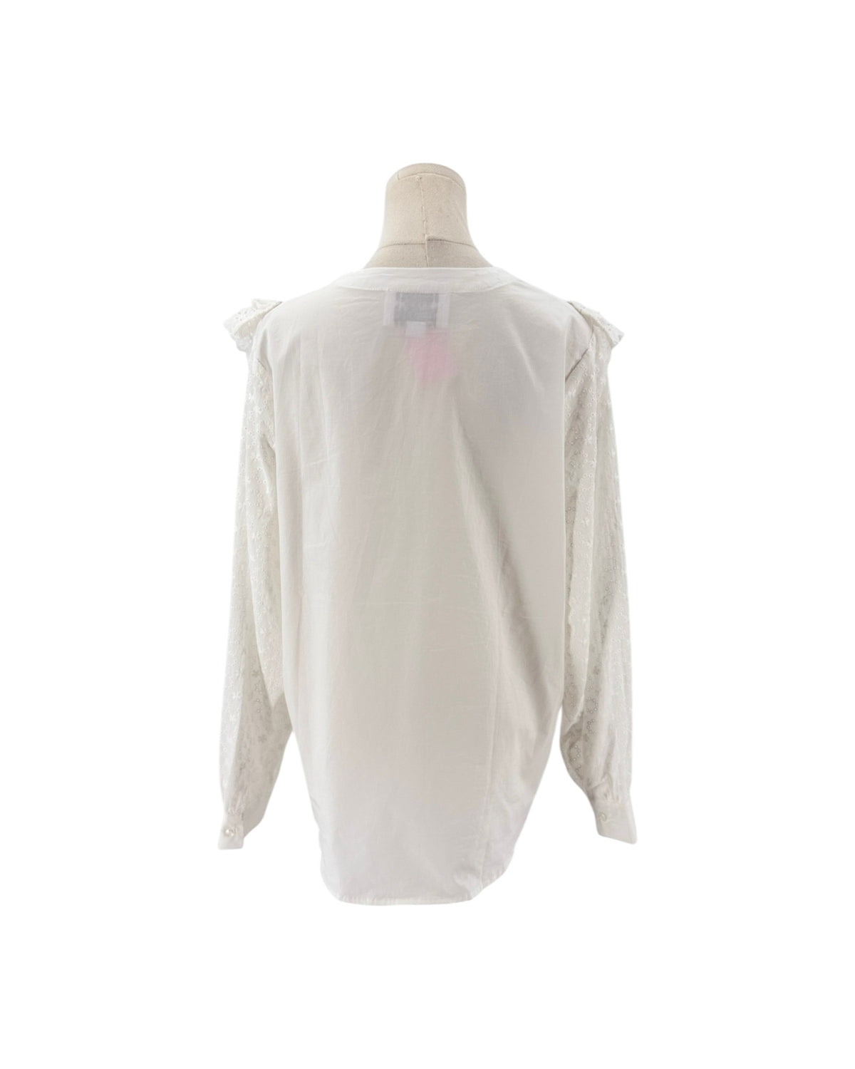 White long sleeve blouse with lace and ruffle details on a mannequin and on a white background