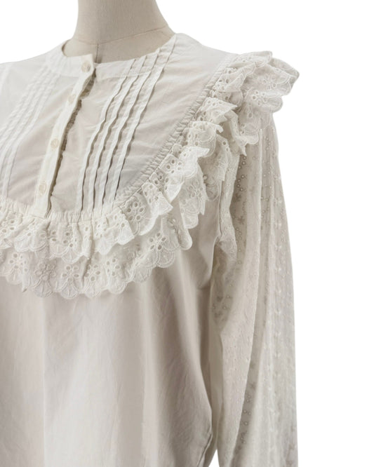 White long sleeve blouse with lace and ruffle details on a mannequin and on a white background