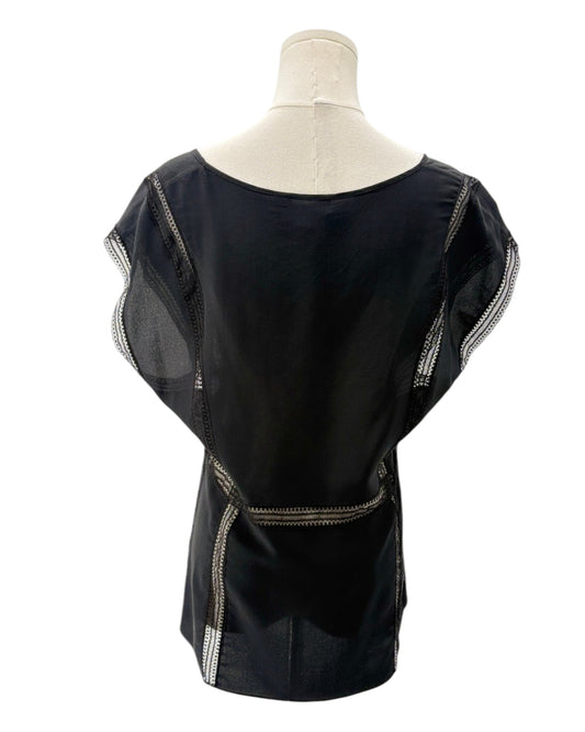 Black top with sheer sleeves on a mannequin against a white background