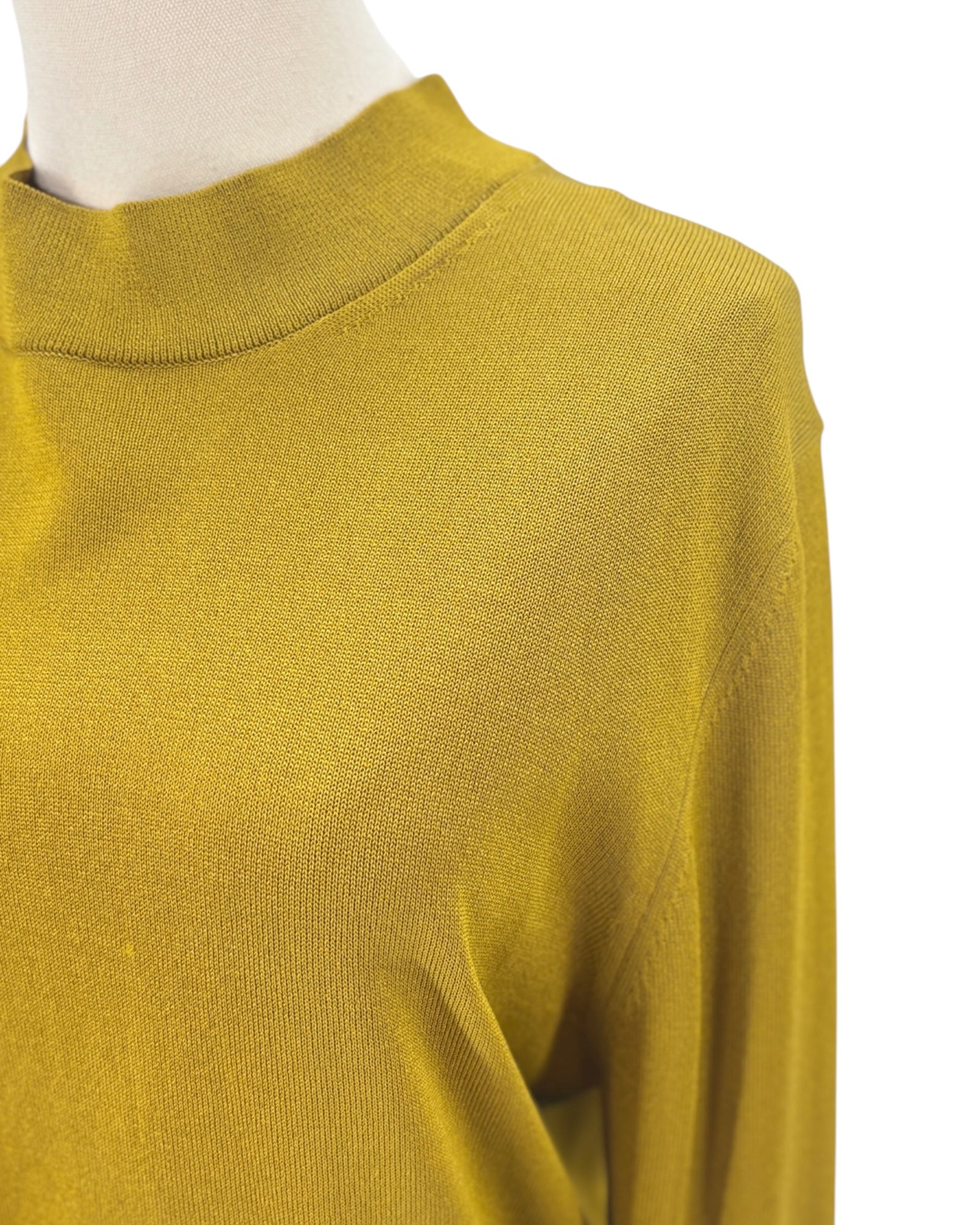 Yellow sweater on a mannequin with a white background