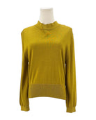 Yellow sweater on a mannequin against a white background