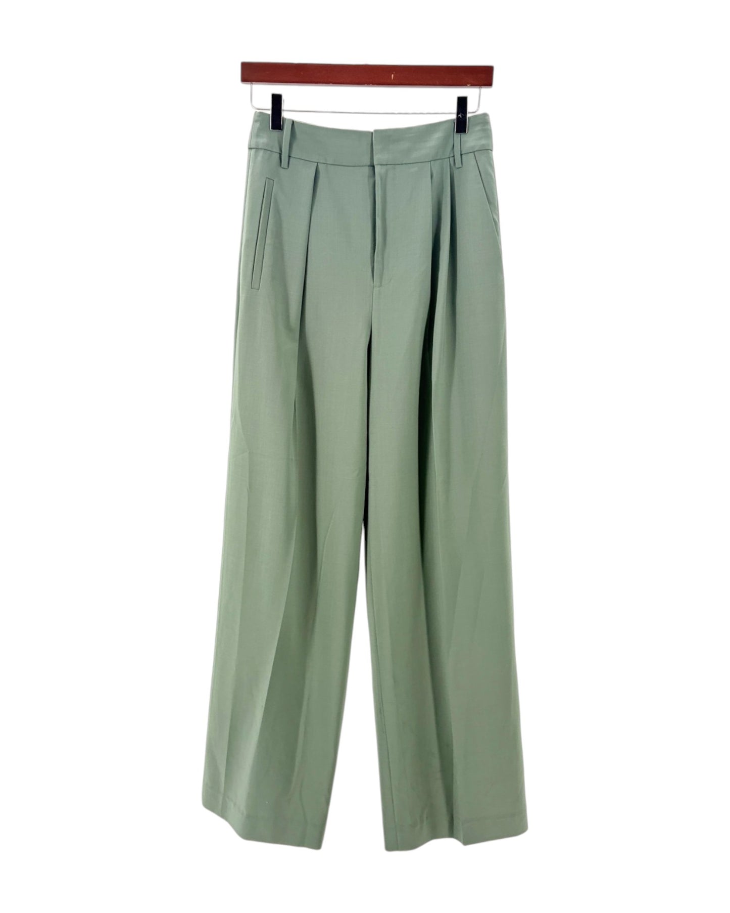 Green pants on a hanger against a white background