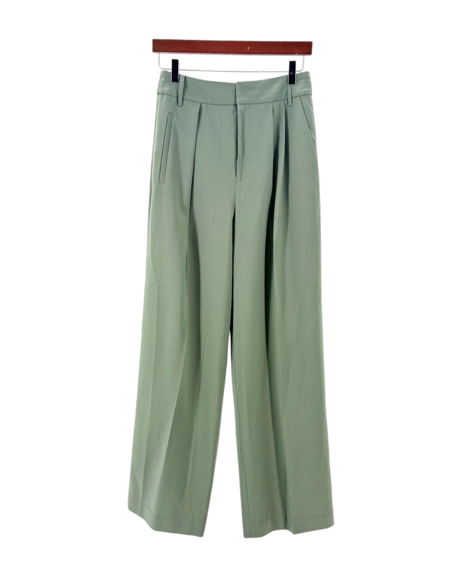 Green pants on a hanger against a white background