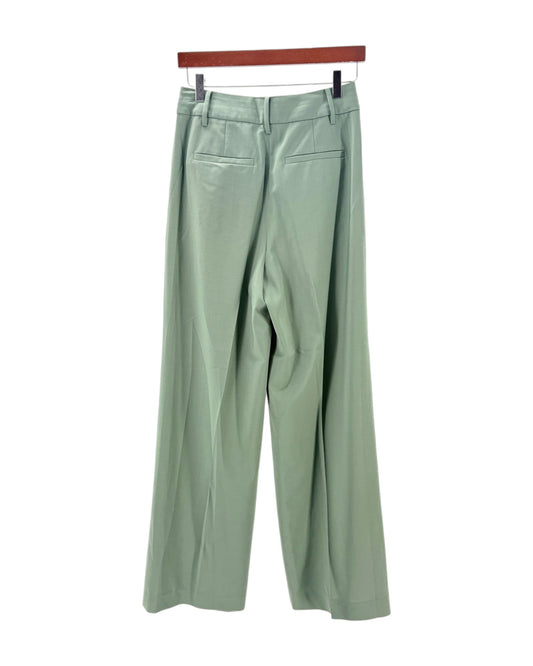 Light green pants on a hanger against a white background