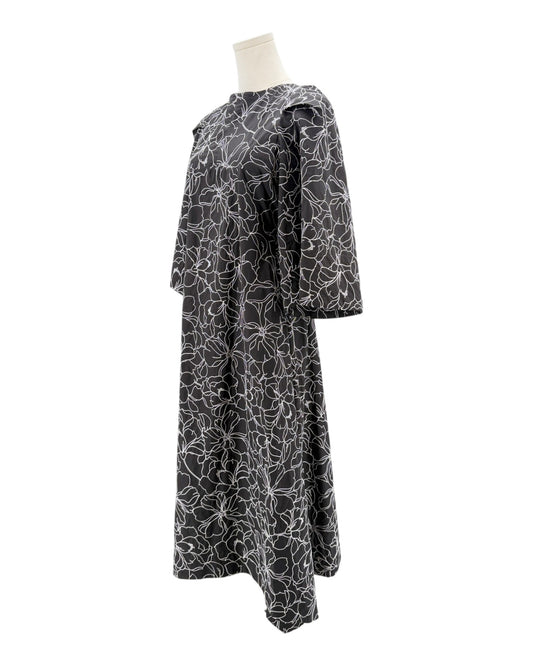Black dress with white floral pattern on a mannequin against a white background