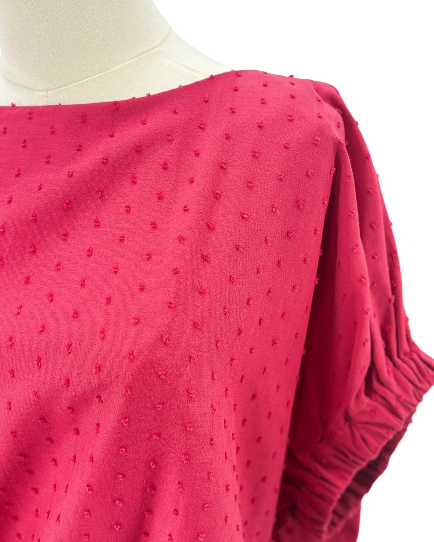 Red top on a mannequin with a white background