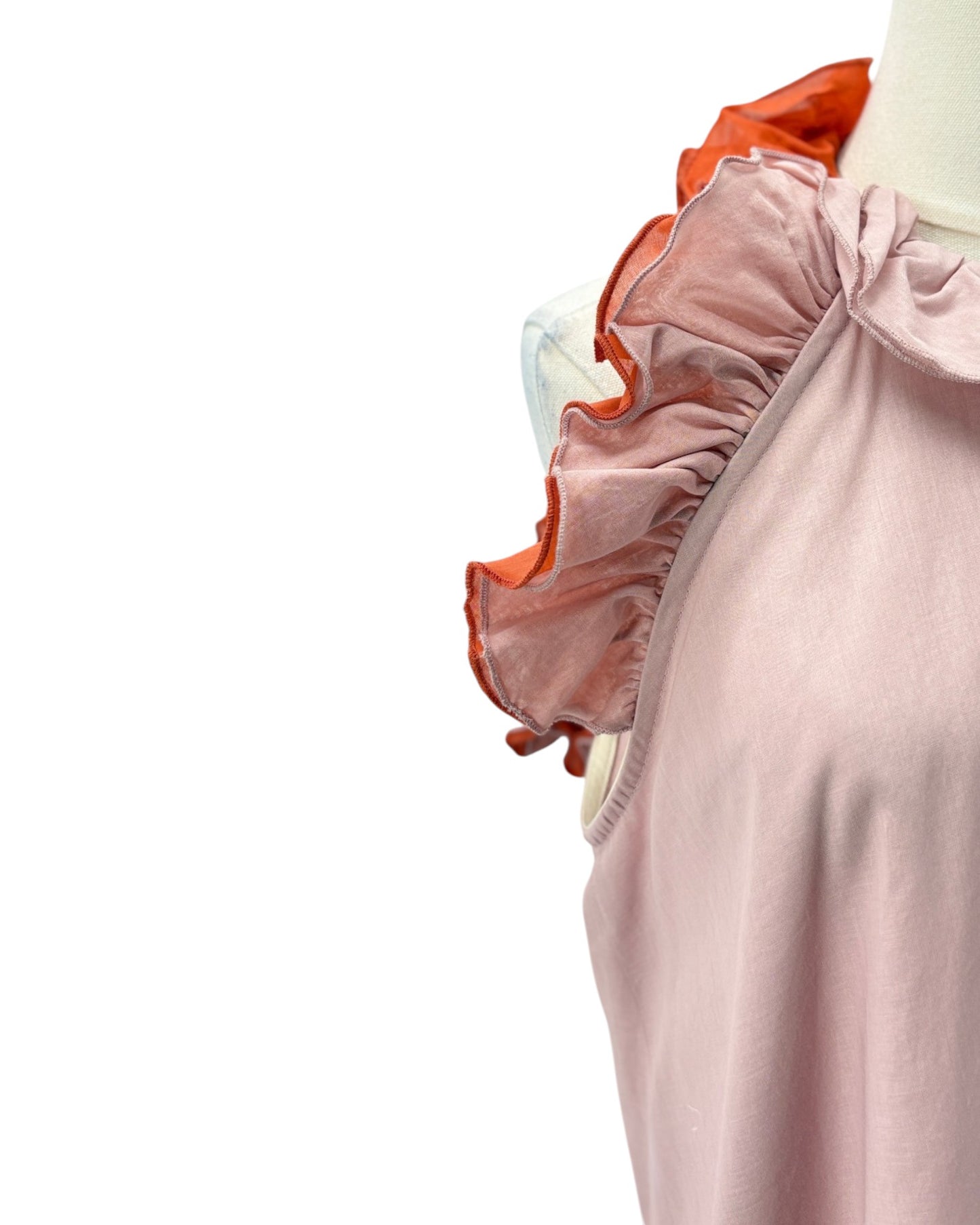 Close-up of a pink garment with ruffled details on a white background