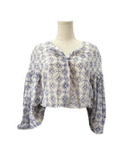Patterned blouse on a mannequin against a white background