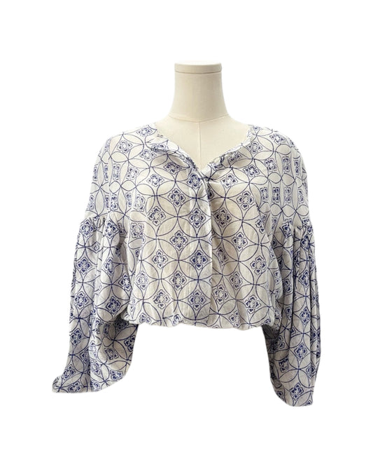 Patterned blouse on a mannequin against a white background