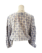 Patterned blouse on a mannequin against a white background