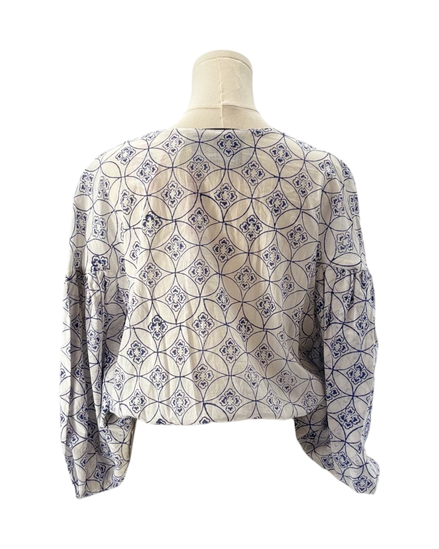 Patterned blouse on a mannequin against a white background