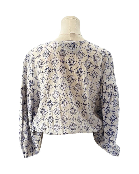 Patterned blouse on a mannequin against a white background