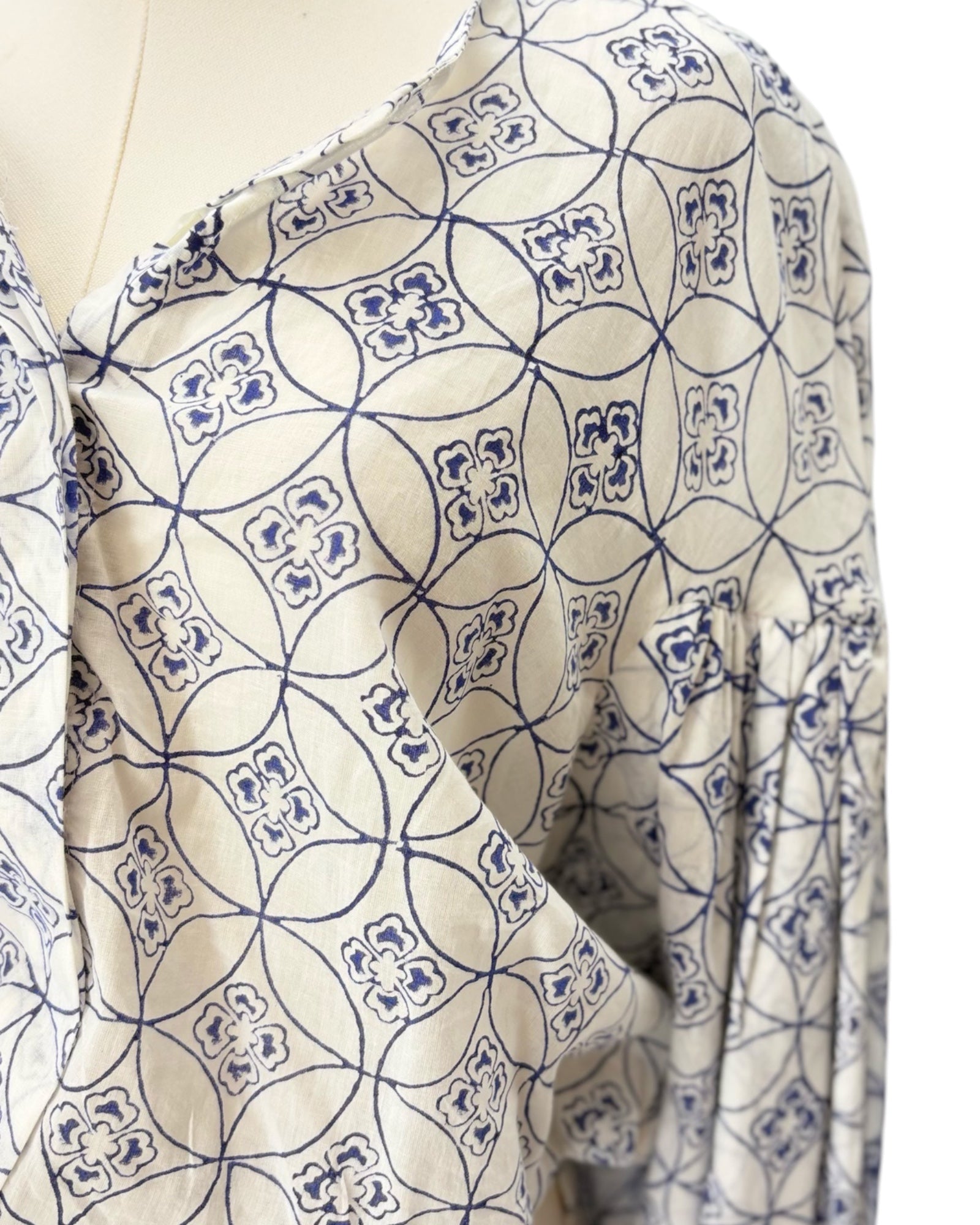 Mannequin wearing a patterned blouse with blue and white design