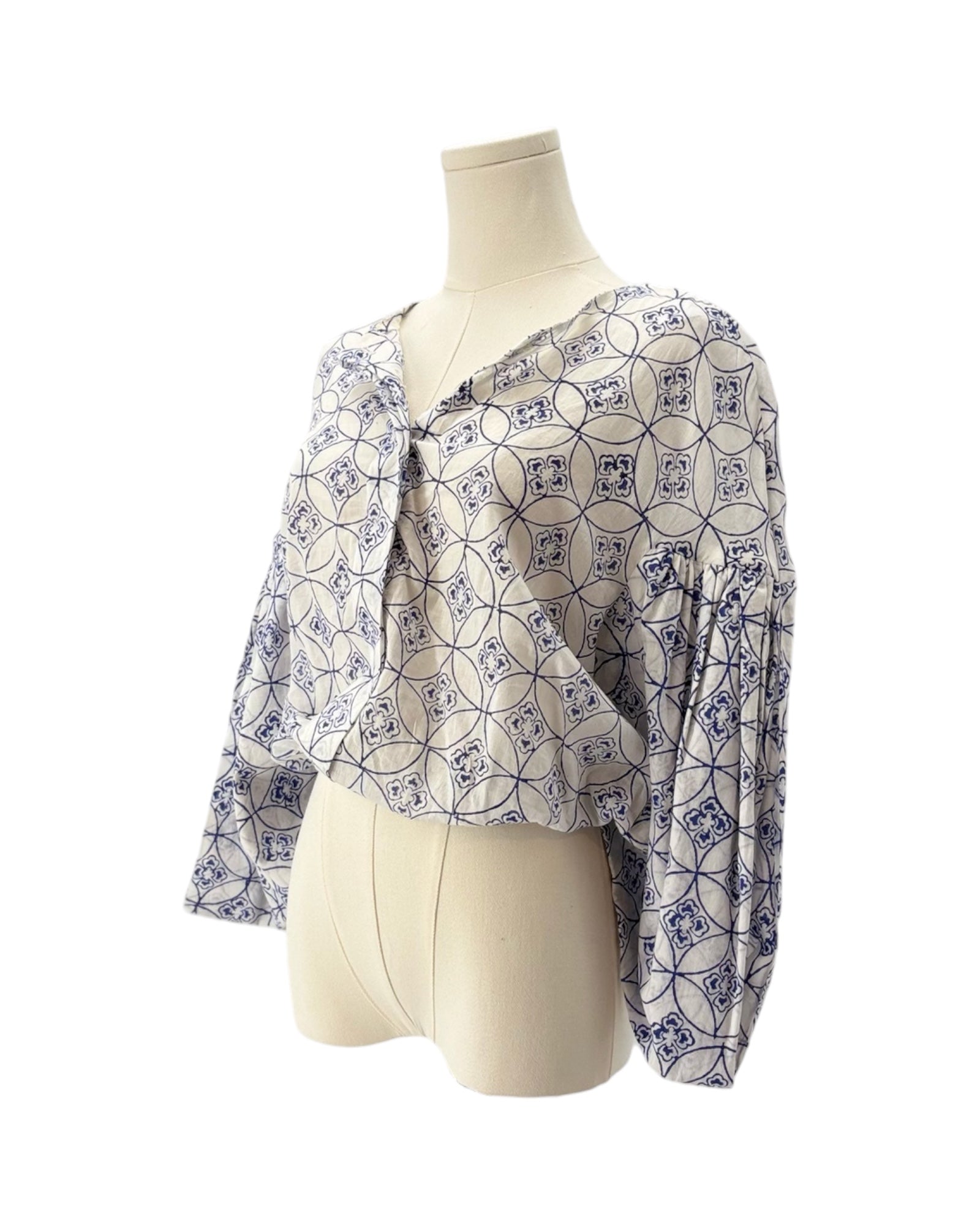 Patterned blouse on a mannequin against a white background