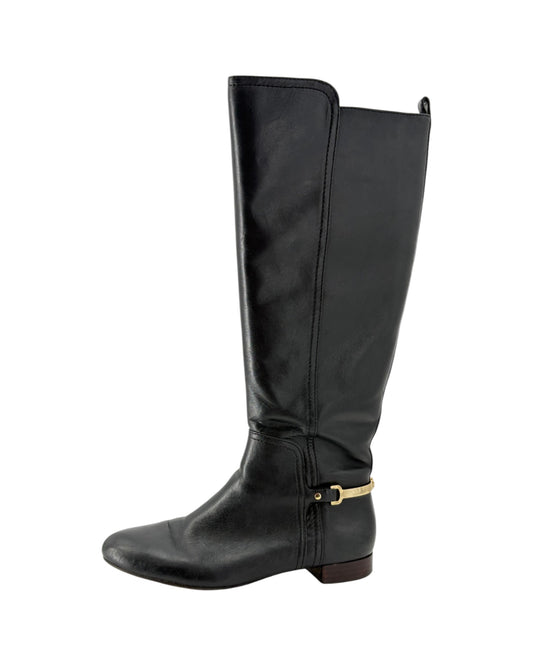 Black knee-high boot with a gold zipper on a white background