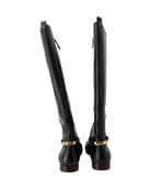 Pair of black knee-high boots with gold accents on a white background