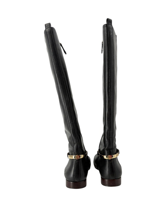 Pair of black knee-high boots with gold accents on a white background