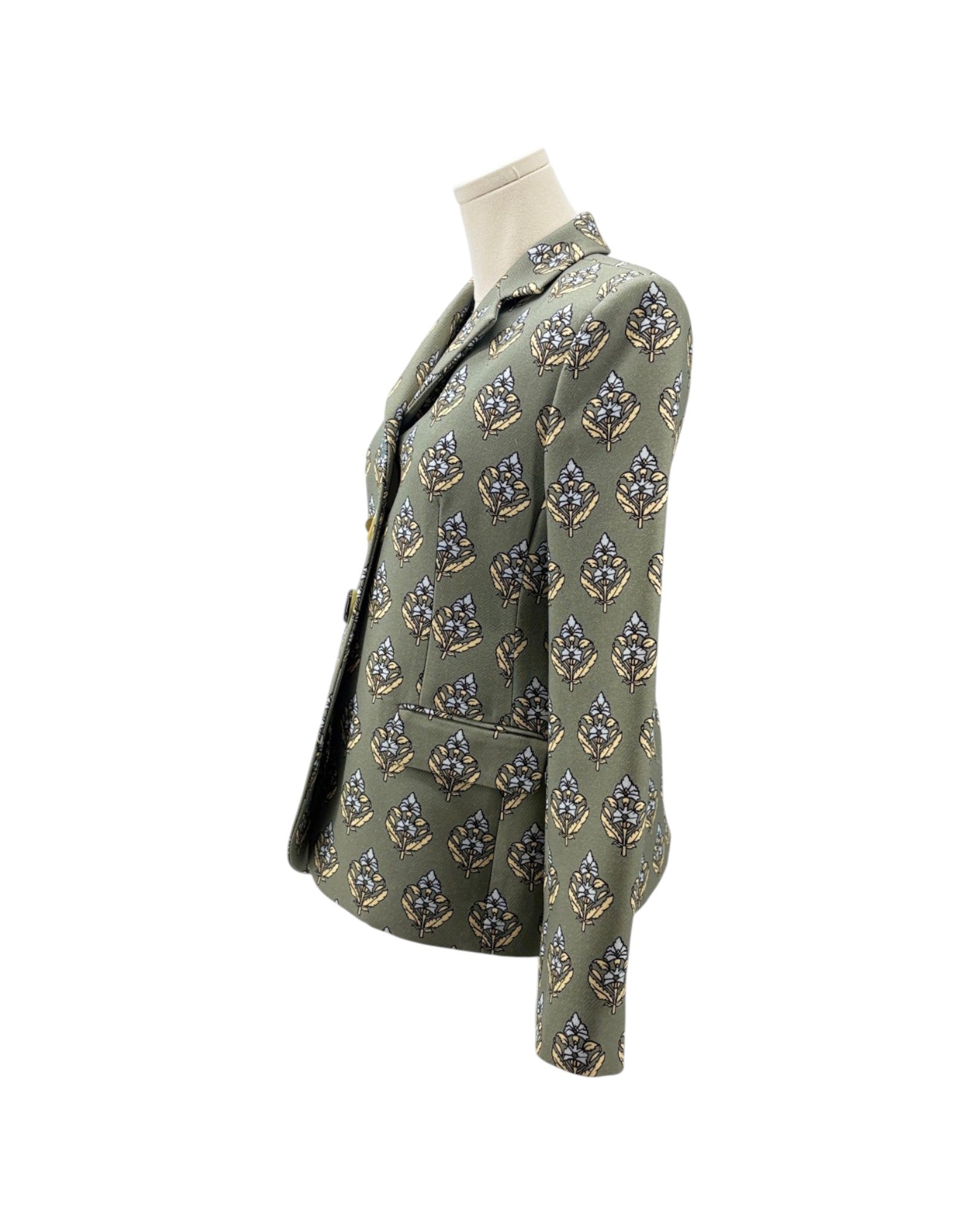 An olive green blazer jacket with a repeating geometric pattern in blue, gold, and white, displayed on a mannequin torso against a white background.
