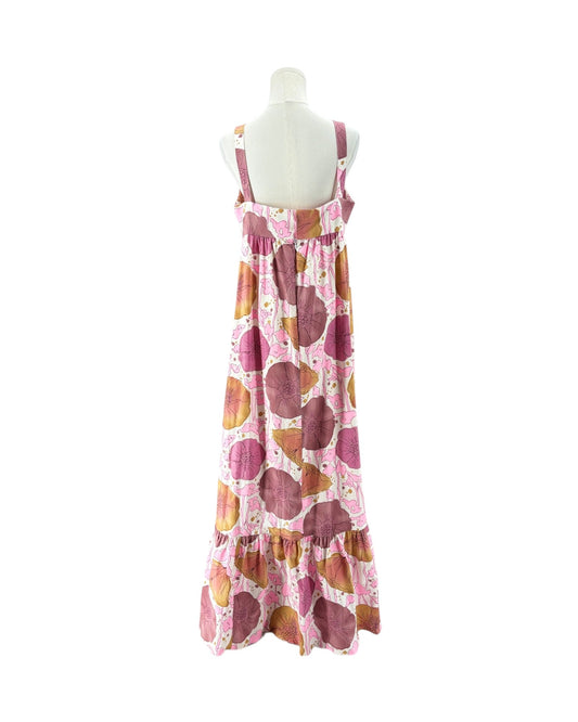 A sleeveless tiered maxi dress with a pink, brown, and orange abstract circle pattern, displayed on a white mannequin torso against a white background.