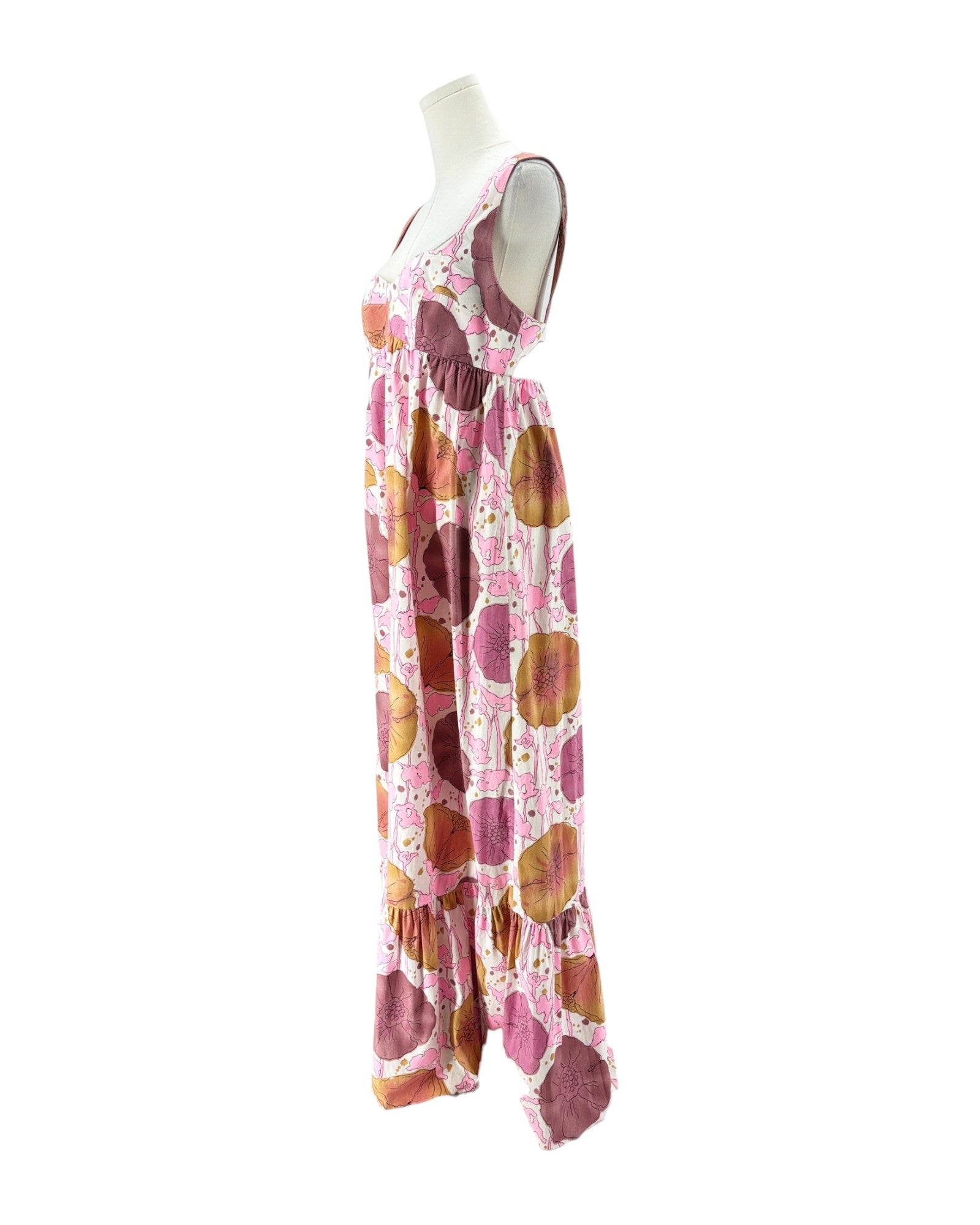 A sleeveless tiered maxi dress with a pink, brown, and orange abstract circle pattern, displayed on a white mannequin torso against a white background.