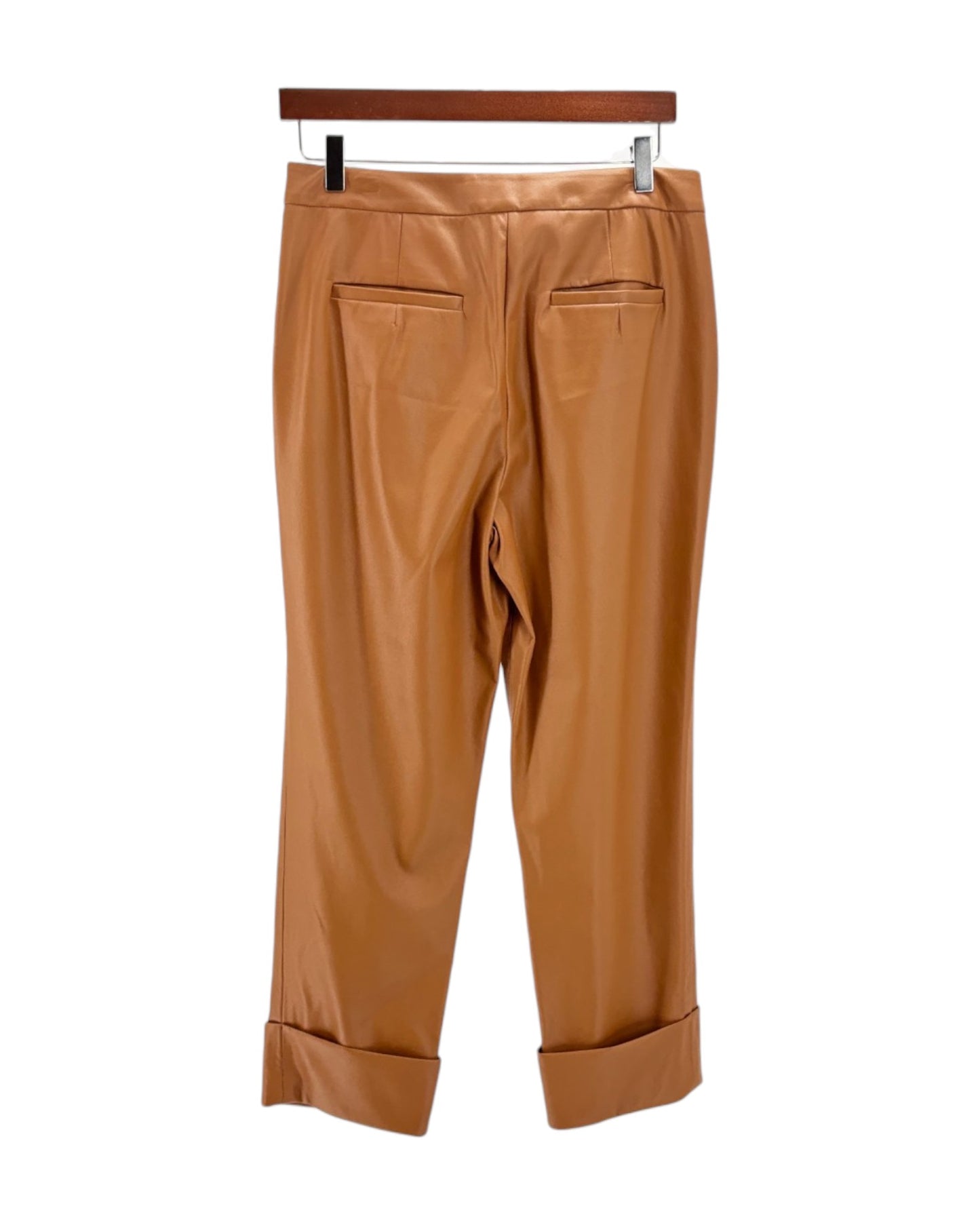 Tan pants on a hanger against a white background