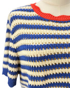 Blue and beige striped sweater with a red neckline on a mannequin.