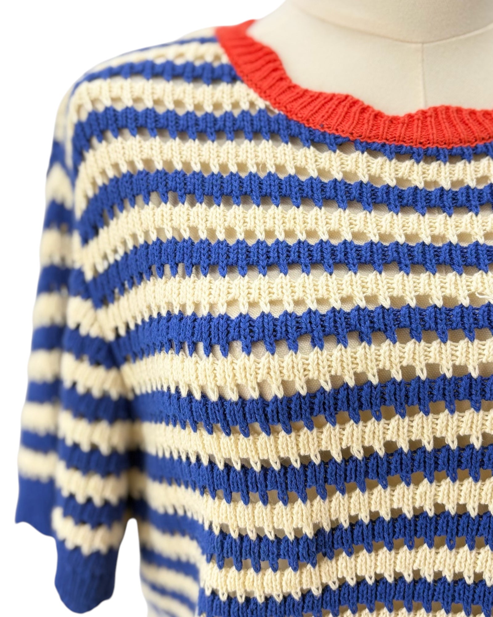 Blue and beige striped sweater with a red neckline on a mannequin.
