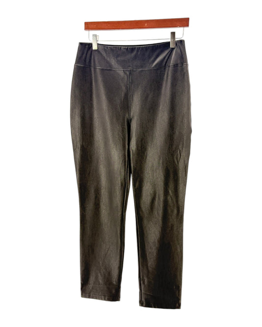 Black pants on a hanger against a white background