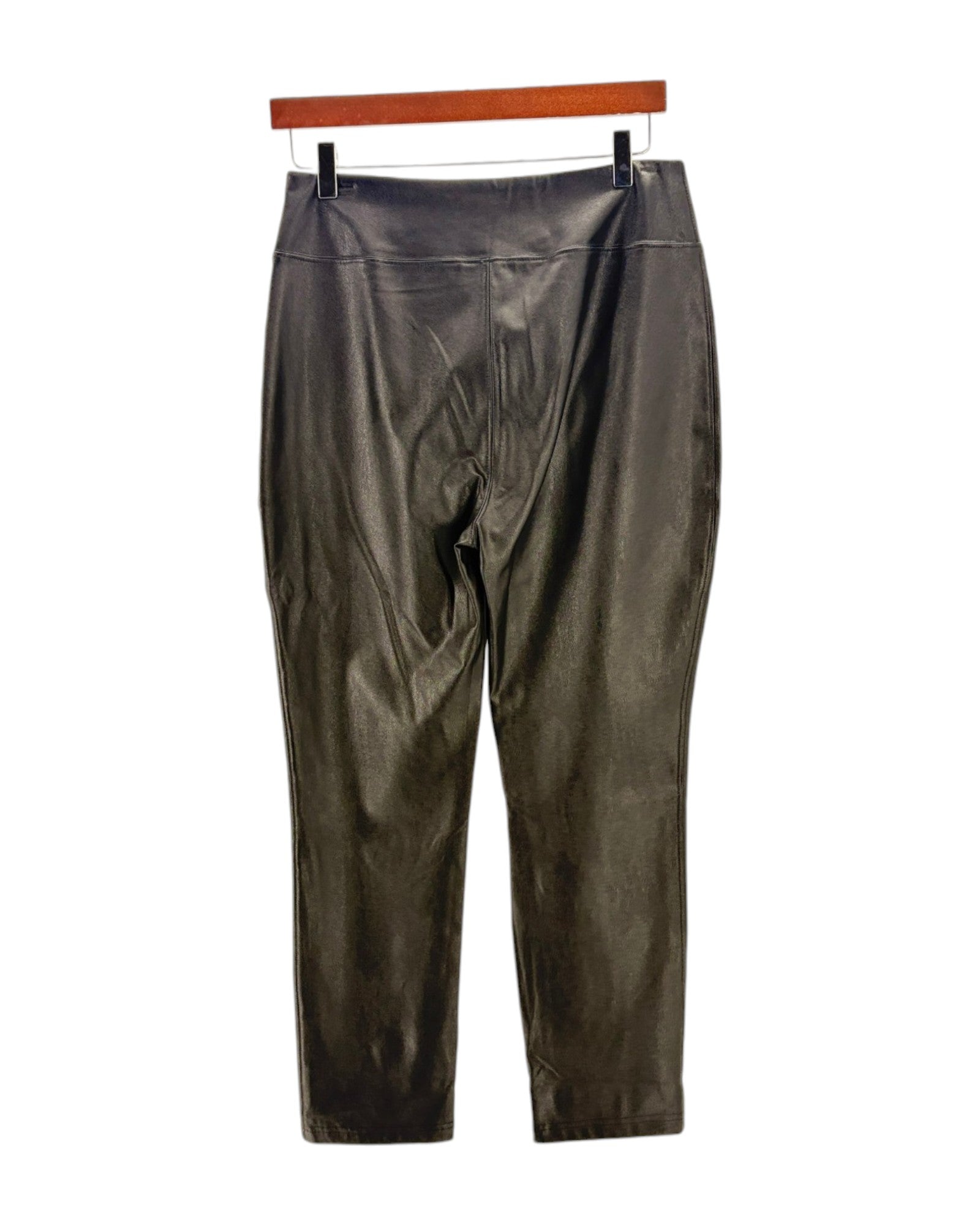 Black leather pants on a hanger against a white background