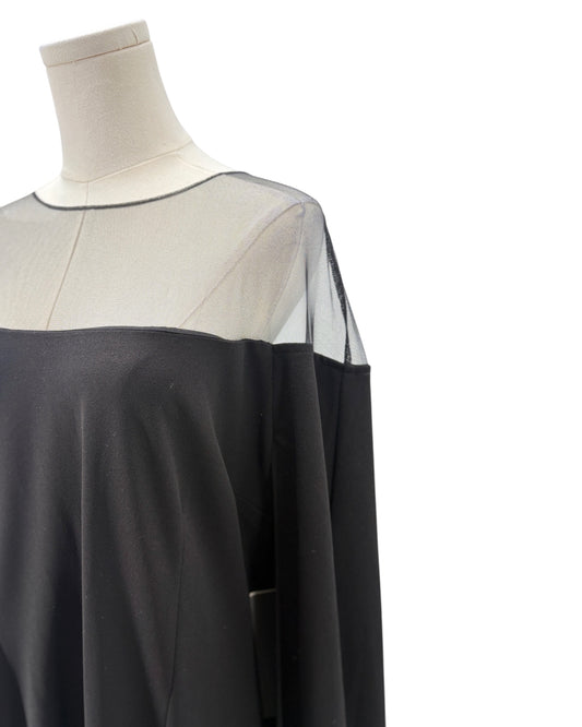 Black and sheer dress on a mannequin against a white background