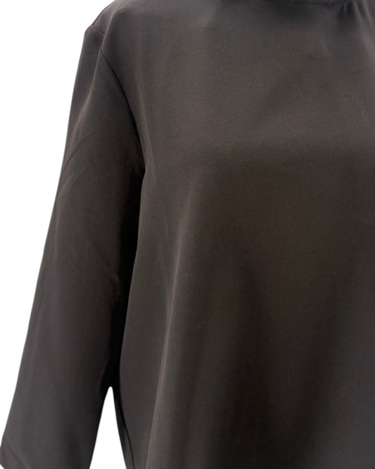 Tuckernuck black blouse with ruffle collar and a bow neckline on a mannequin against a white background