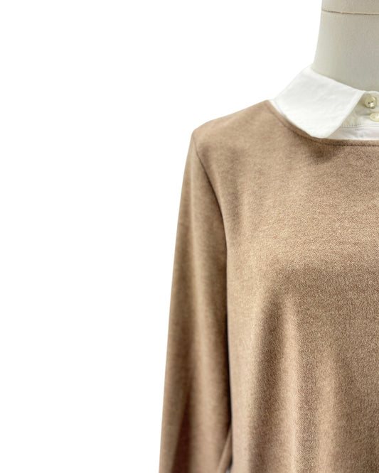 A close-up of a beige knit sweater with a white pointed collar, displayed on a mannequin torso against a plain white background.