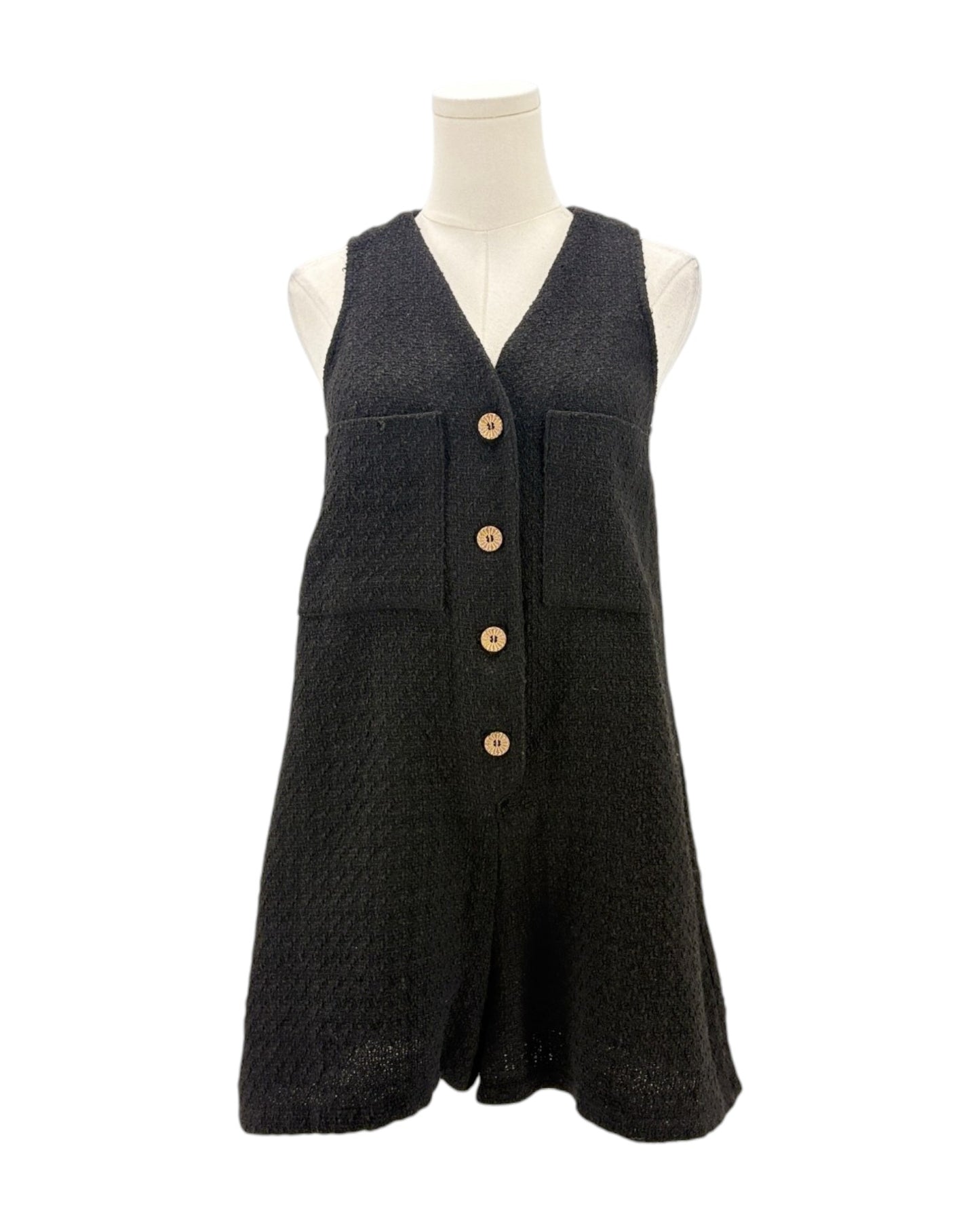 Black sleeveless romper with button details on a mannequin against a white background