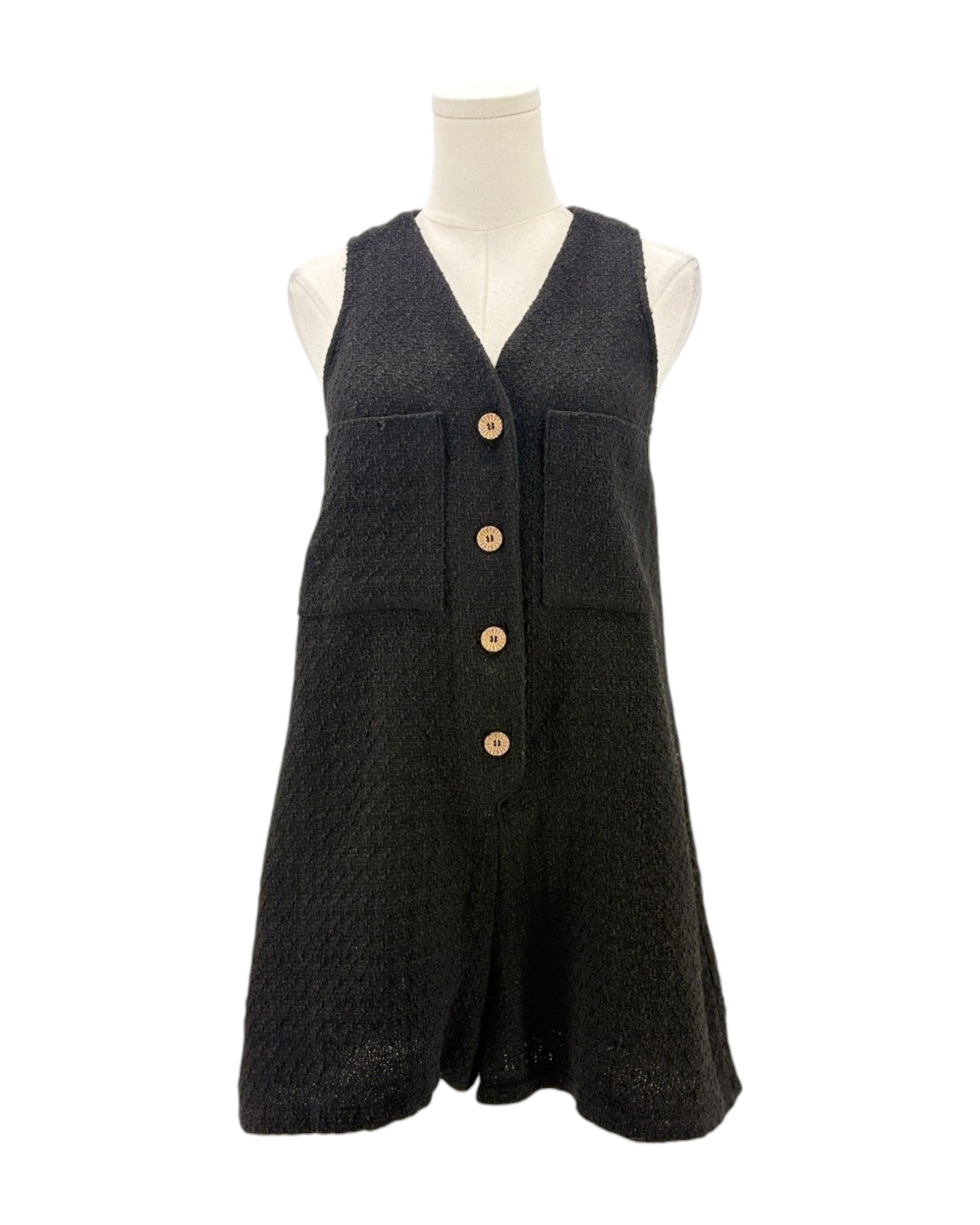 Black sleeveless romper with button details on a mannequin against a white background