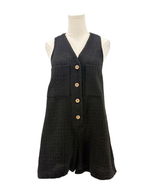 Black sleeveless romper with button details on a mannequin against a white background