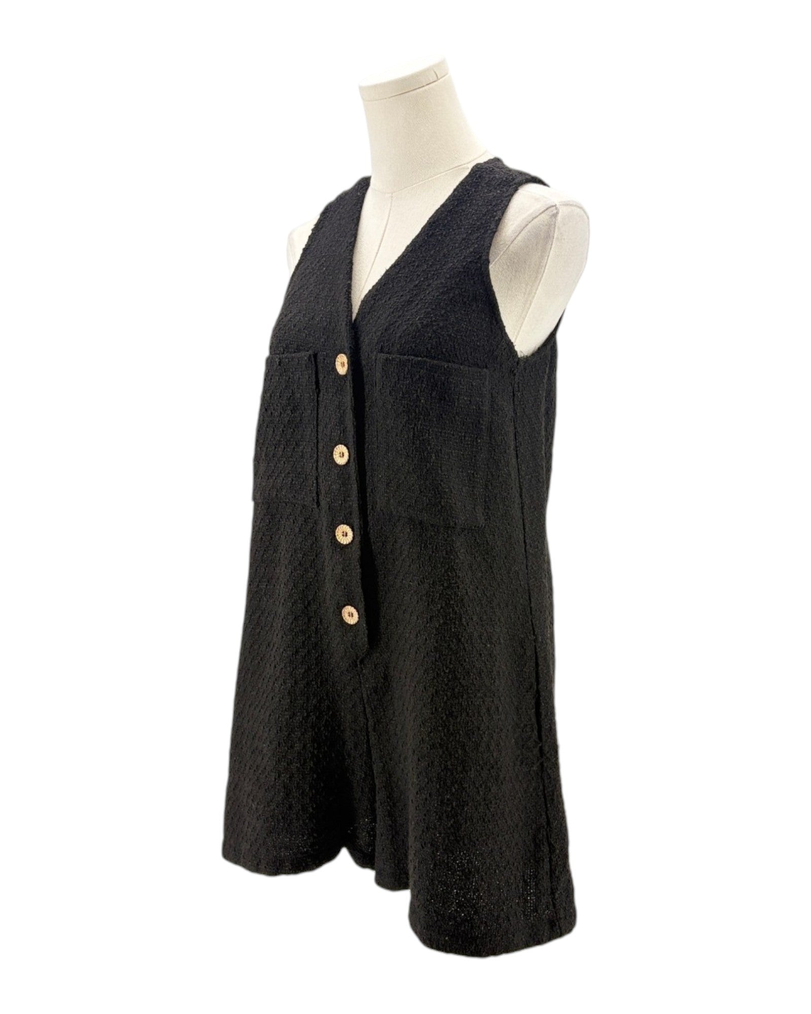 Black sleeveless romper with button details on a mannequin against a white background
