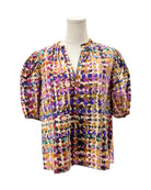 Multicolored floral blouse on a mannequin against a white background