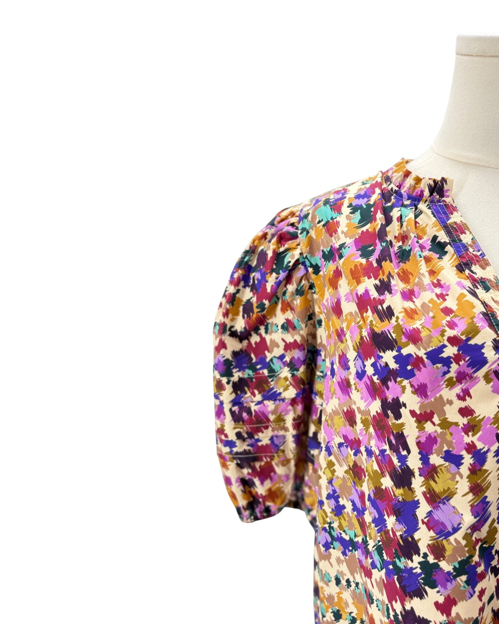 Colorful floral dress on a mannequin against a white background