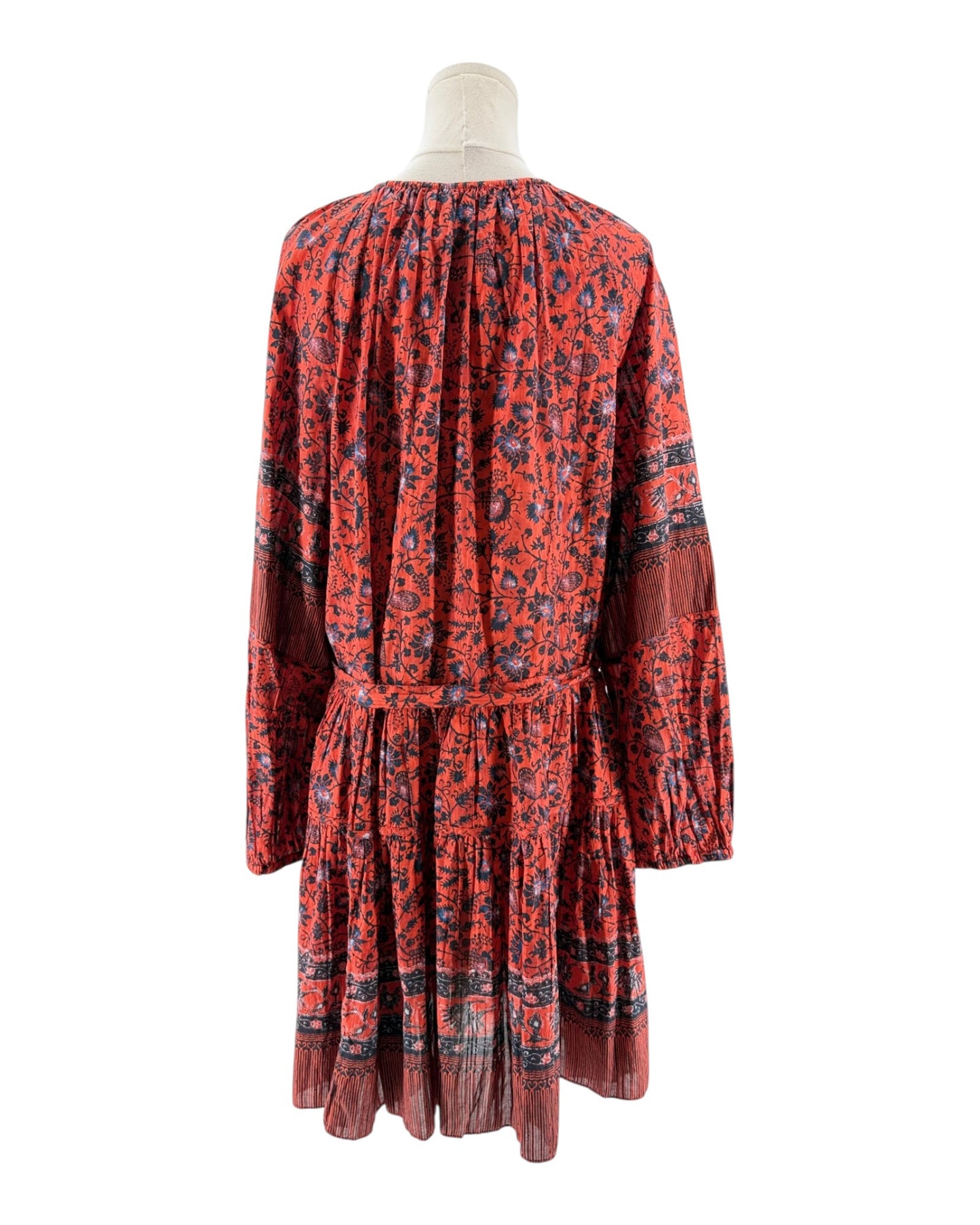 Red patterned dress on a mannequin against a white background