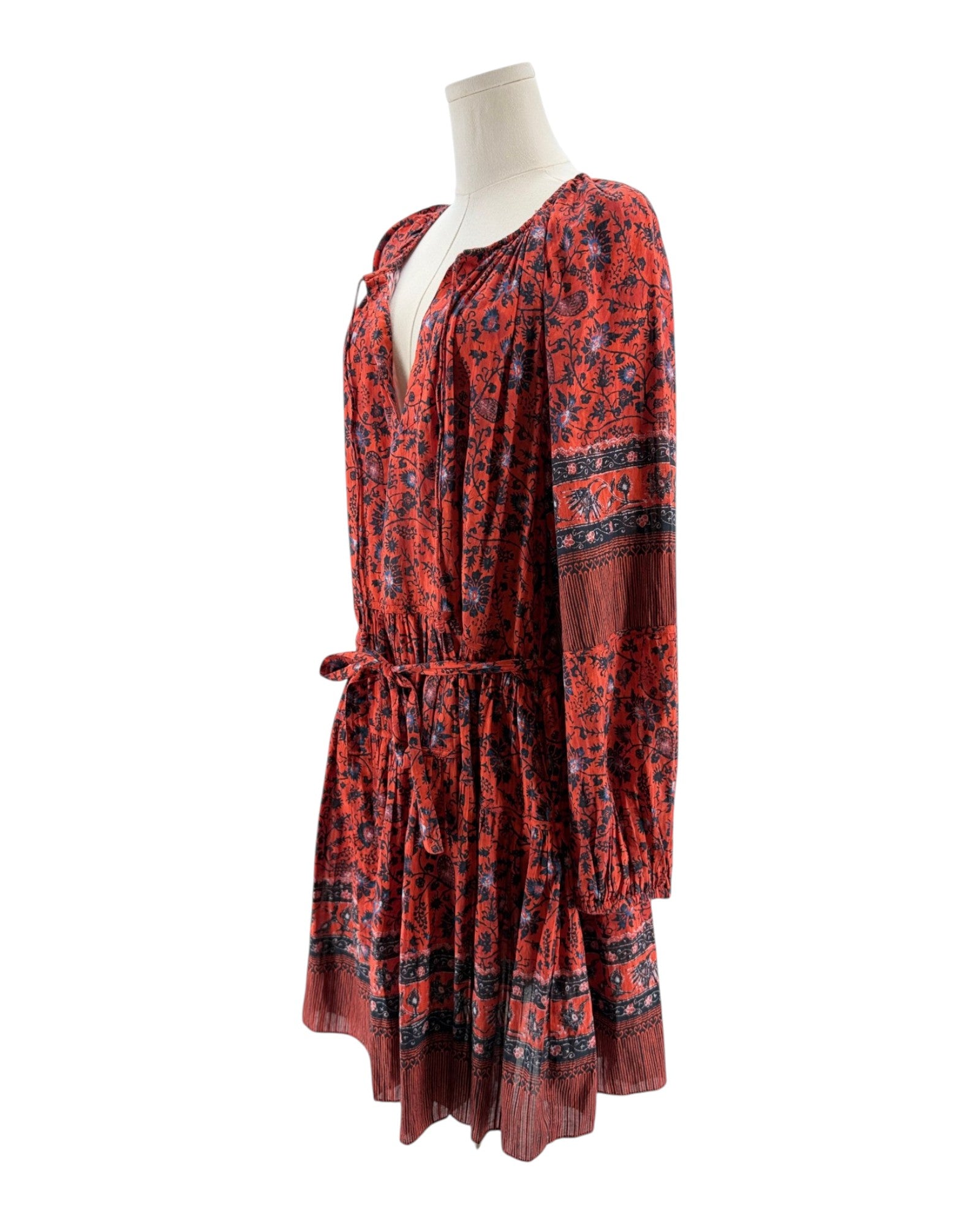 Red patterned dress on a mannequin against a white background