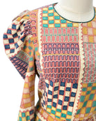 Colorful patterned dress on a mannequin against a white background
