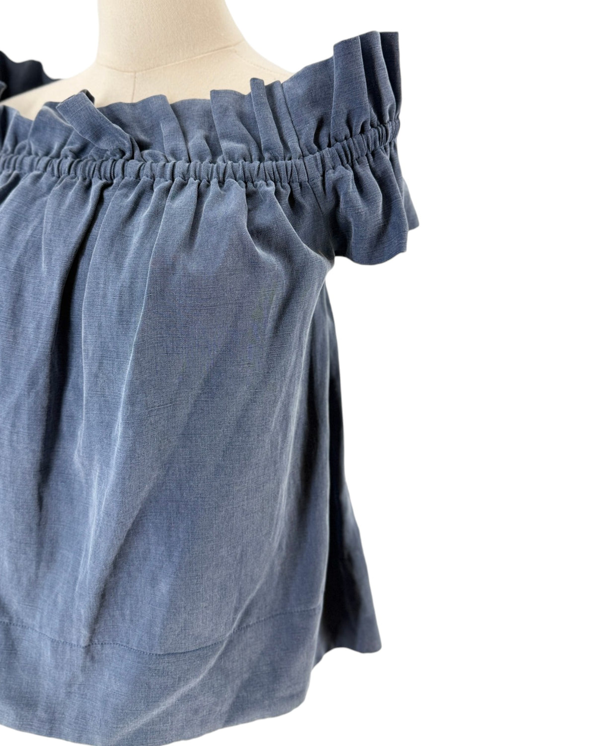 Blue off the shoulder top on a mannequin on a white background