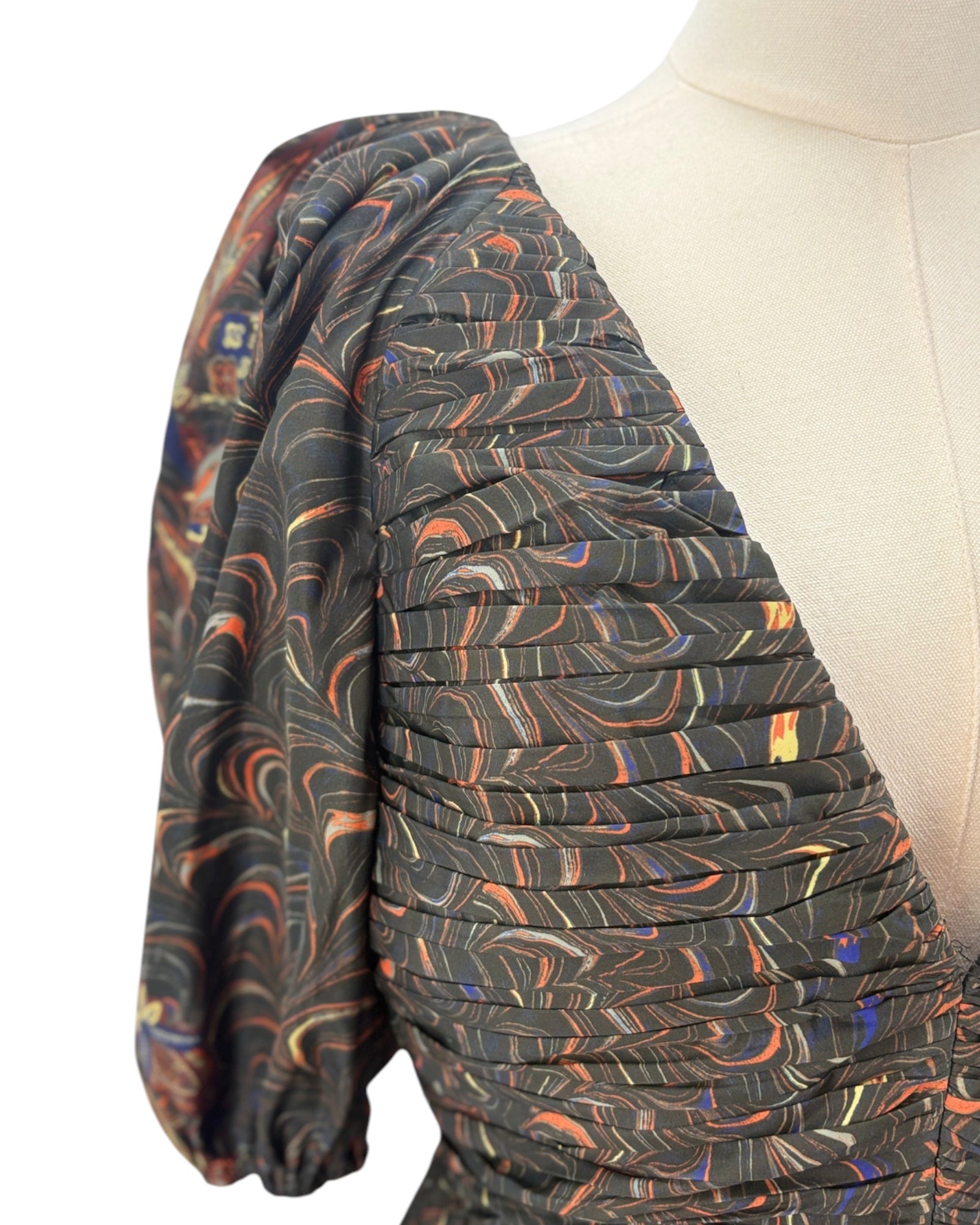 Patterned fabric dress on a mannequin on a white background