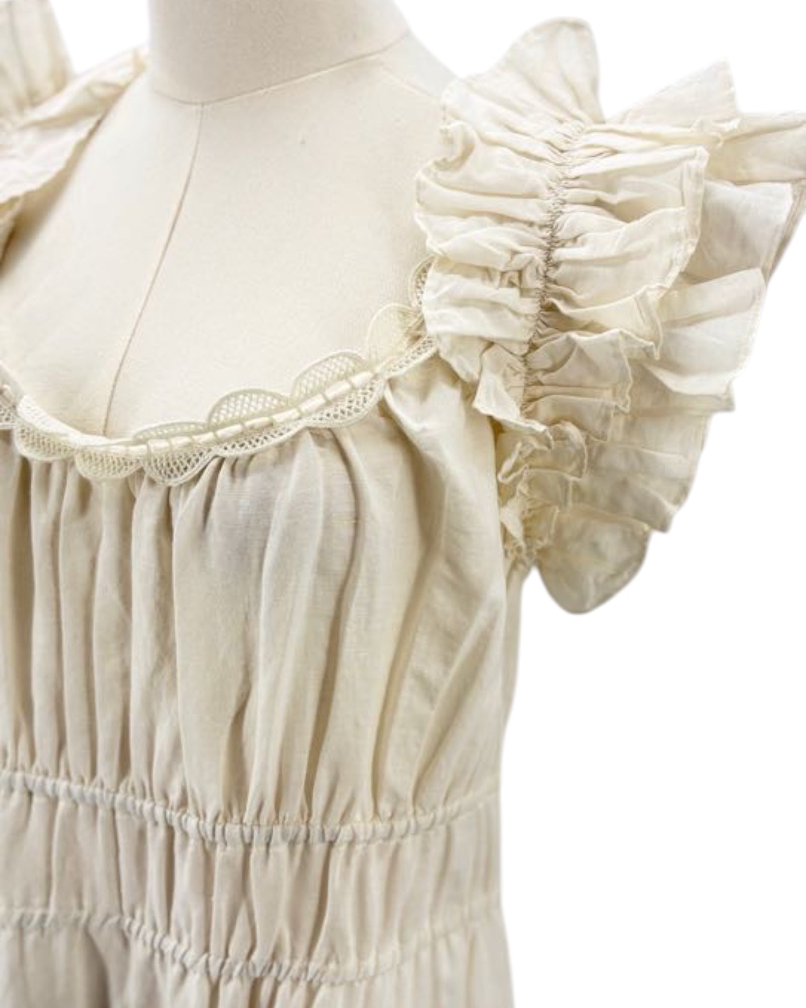 Ulla Johnson cream dress with ruffled sleeves on a mannequin against a white background