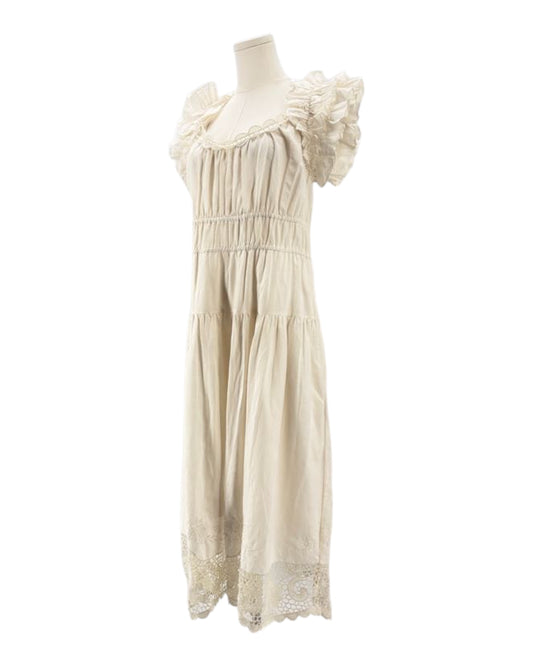 Ulla Johnson cream dress with ruffled sleeves on a mannequin against a white background