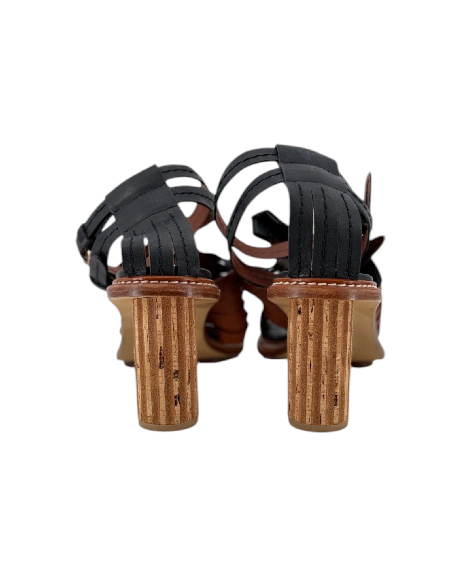 A pair of women's strappy sandals shown from the back, featuring black leather straps and chunky ribbed cork block heels in a natural brown tone, set against a plain white background.