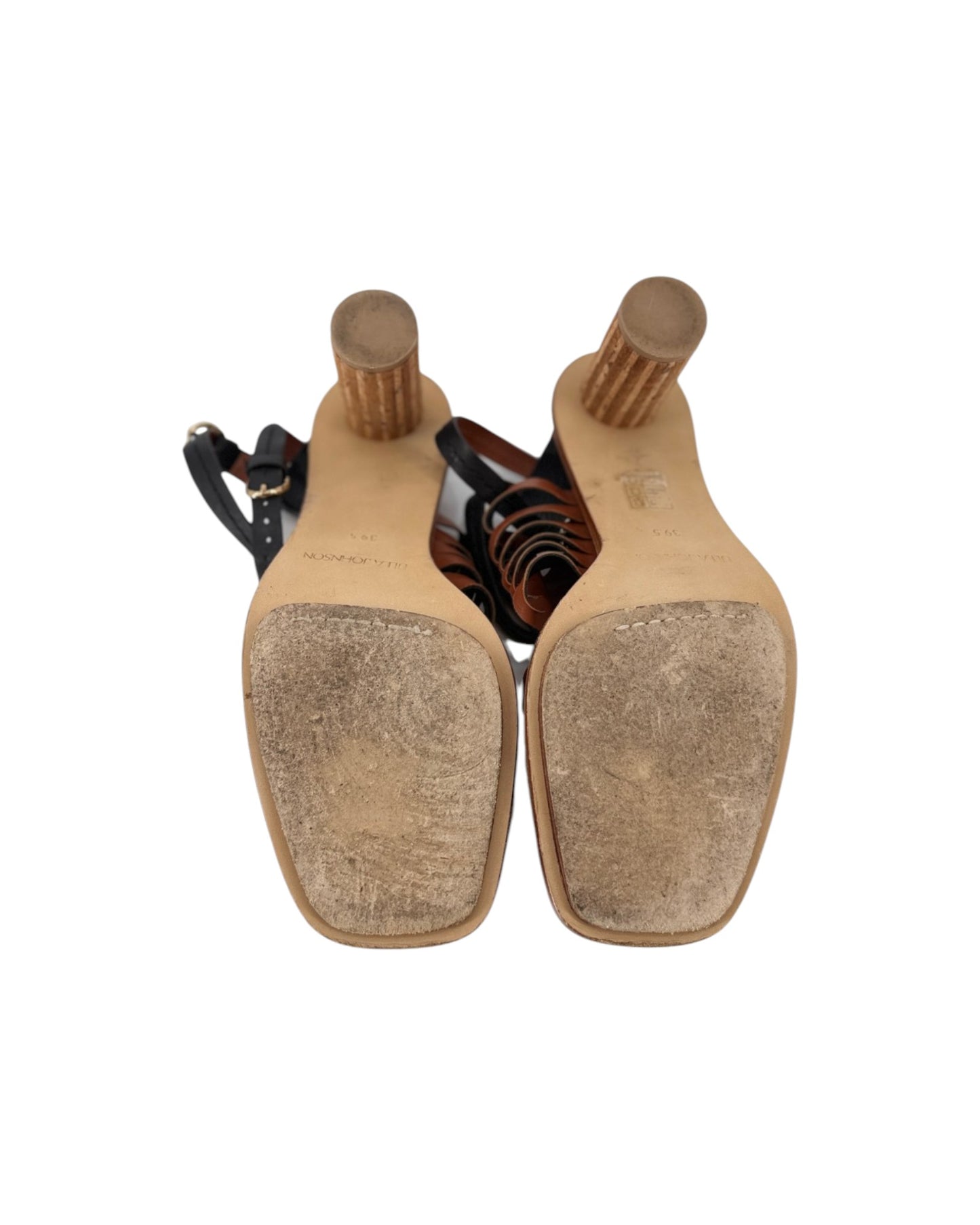 A pair of women's heeled sandals shown from a top-down view, featuring a tan leather upper with a black ankle strap and a distinctive ribbed wooden block heel.